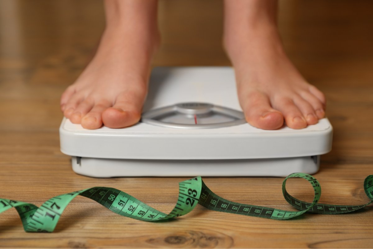 Young person standing on a set of scales. Copyright: Liudmila Chernetska iStock