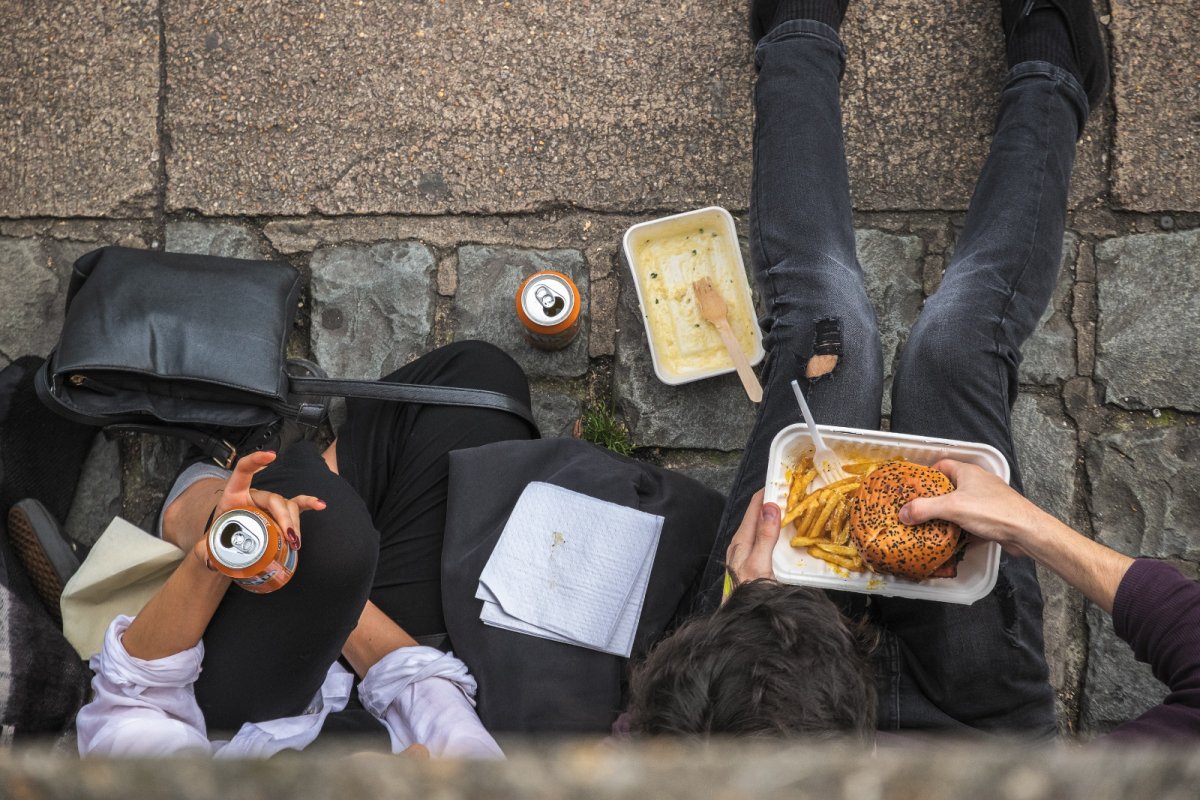 Top view of two people eating takeaway on street. Copyright: I Wei Huang | Shutterstock