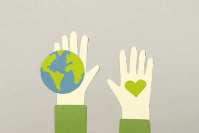 Illustrated hands up showing an earth and a heart. Credit: Artem Podrez | Pexels