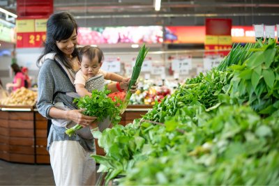 Mother carrying her baby while shopping in grocery store. Copyright: Odua Images | shutterstock